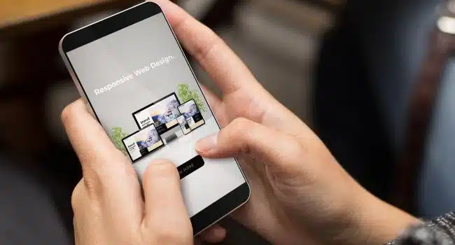 pessoa segurando um celular e navegando em um site responsivo