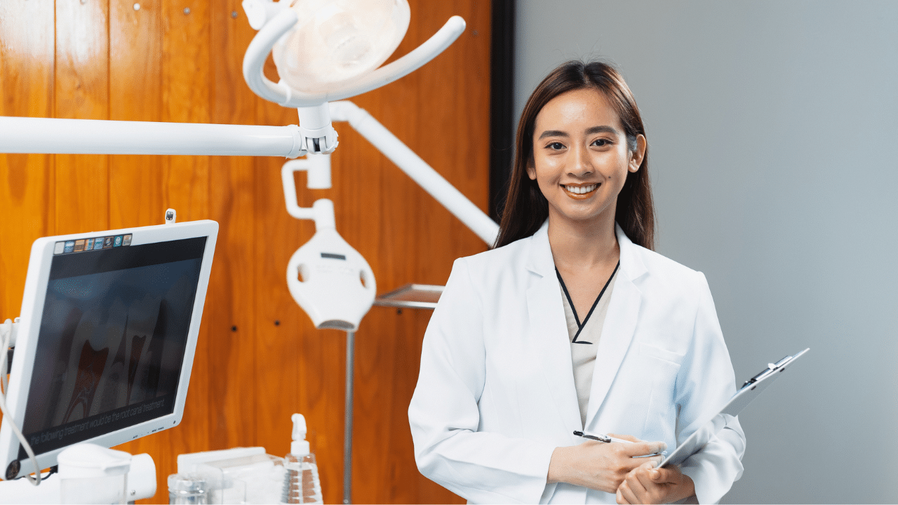 dentista vestida de branco e sorrindo após contratar os serviços de seo para clínica odontológica