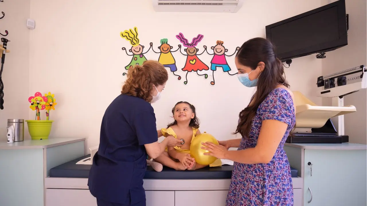 mãe acompanhando sua filha enquanto ela é consultada por uma média pediátrica