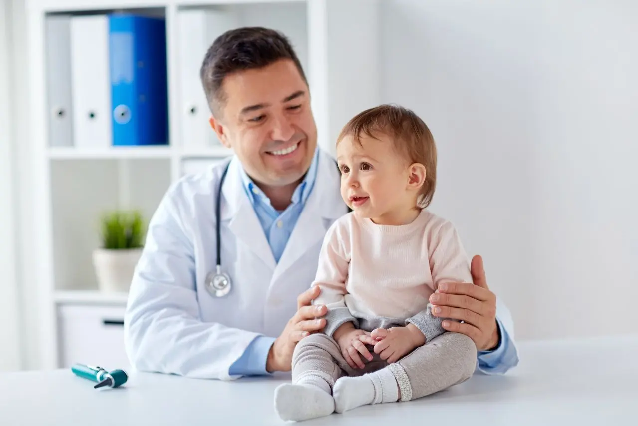 médico pediatra tirando uma foto com uma criança que ele acabou de consultar